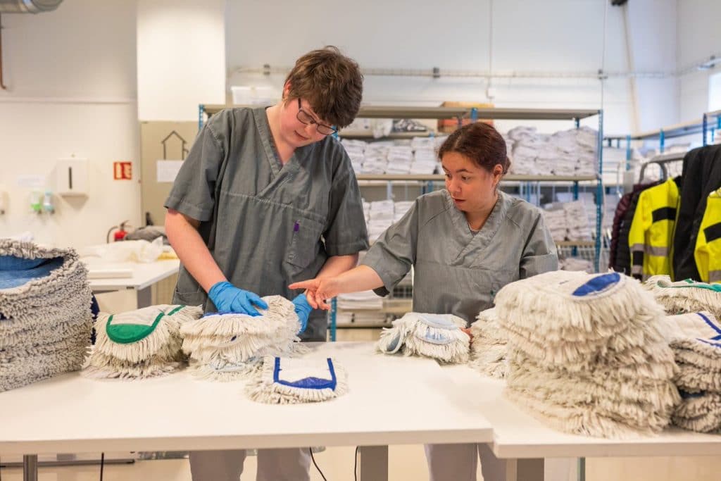 Ansatte gjør klart mopper på vaskeriet