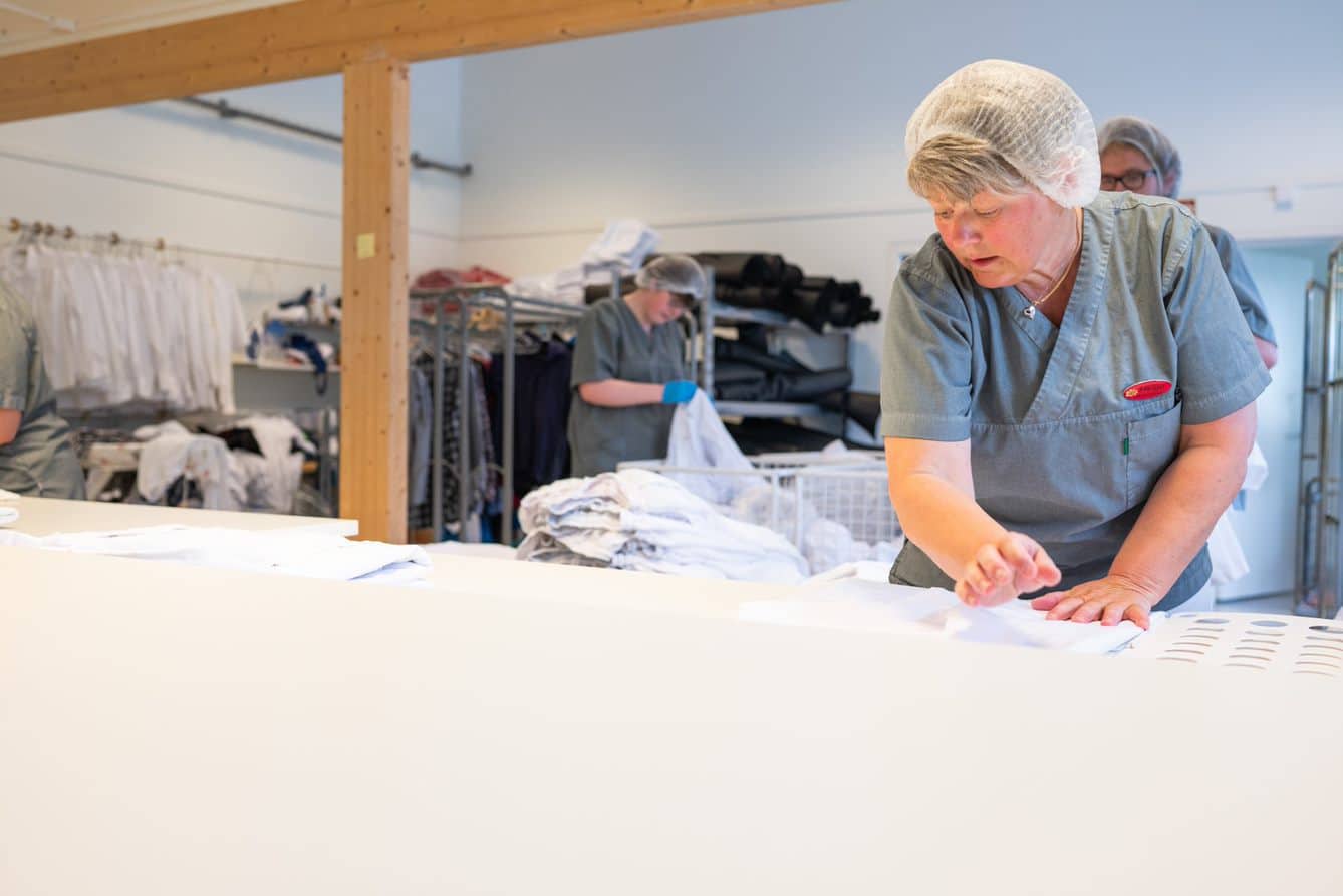 Arbeider på vaskeritet bretter klær